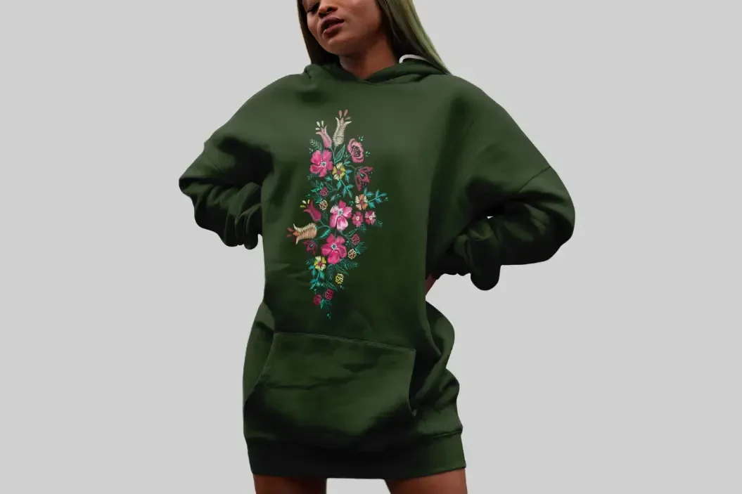 Woman wearing a green hoodie with a floral desing printed on it