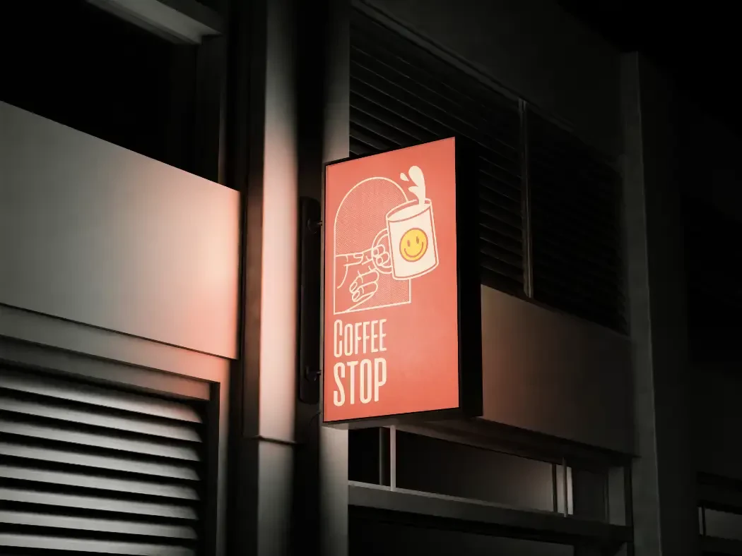Lighted sign hanging on the side of a coffee shop