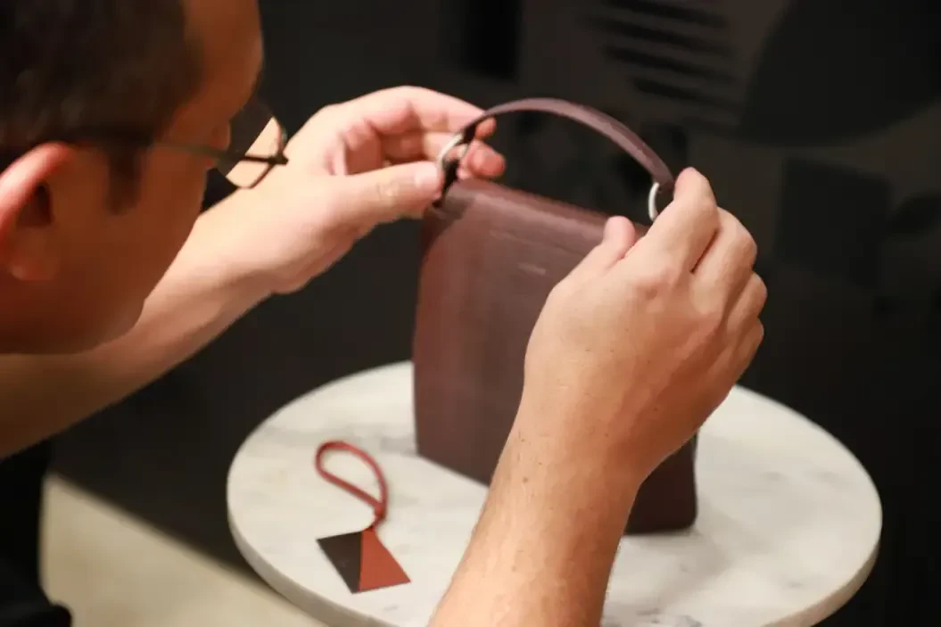 Man adjusting the handle of a purse