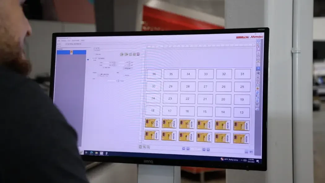 Man looking at print layouts on a screen