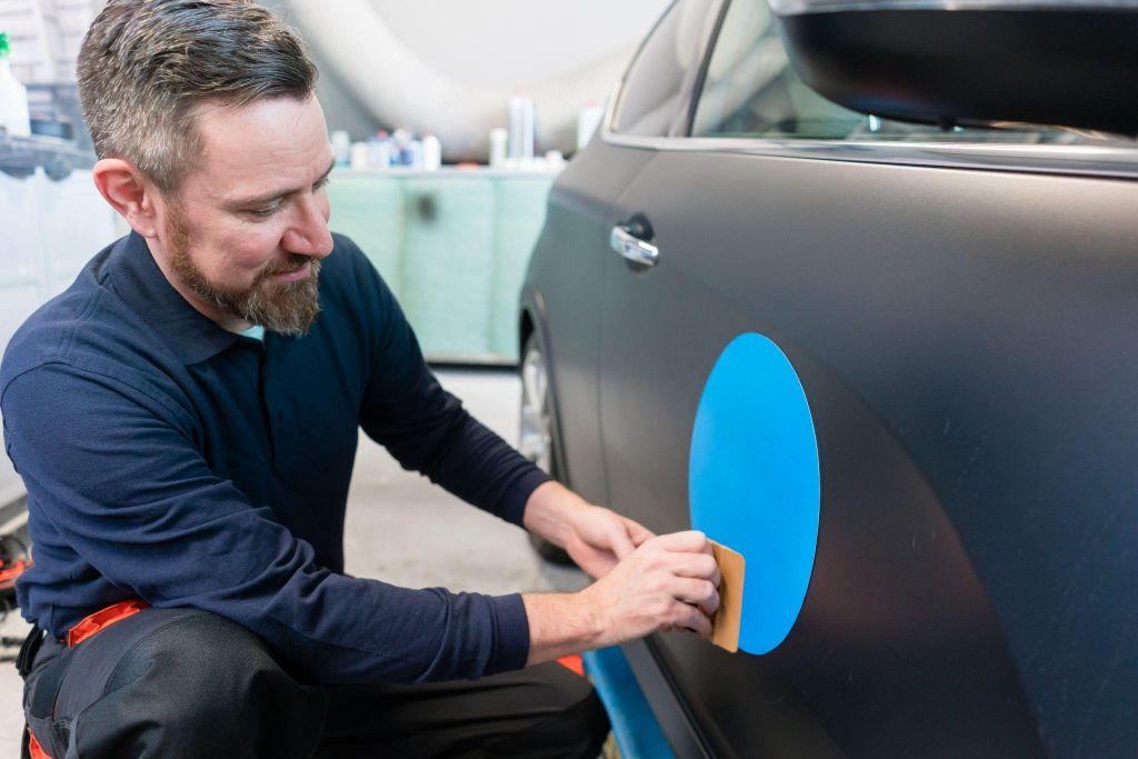 Man putting sticker on a car